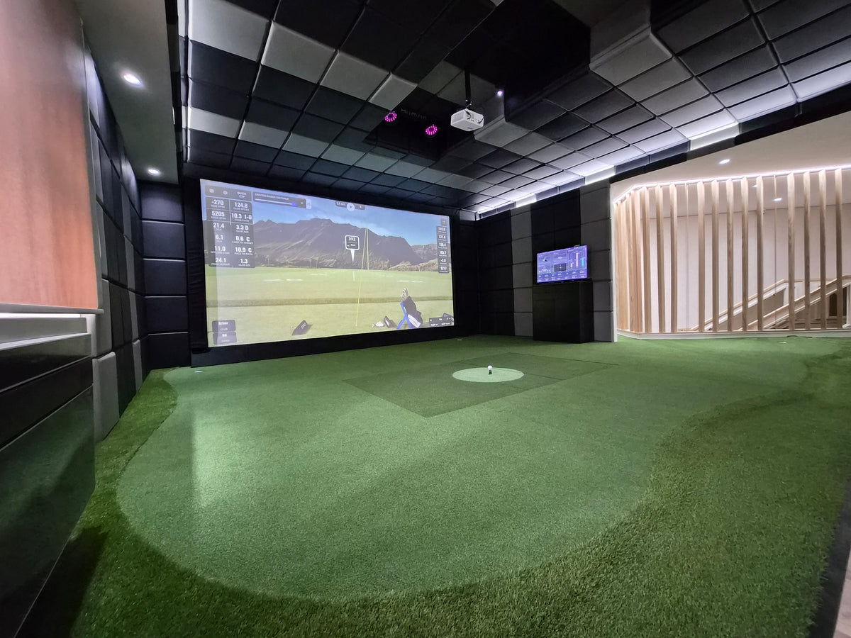 Complete commercial indoor golf installation, viewed from the hitting area, showing the immersive simulation experience and high-quality setup.