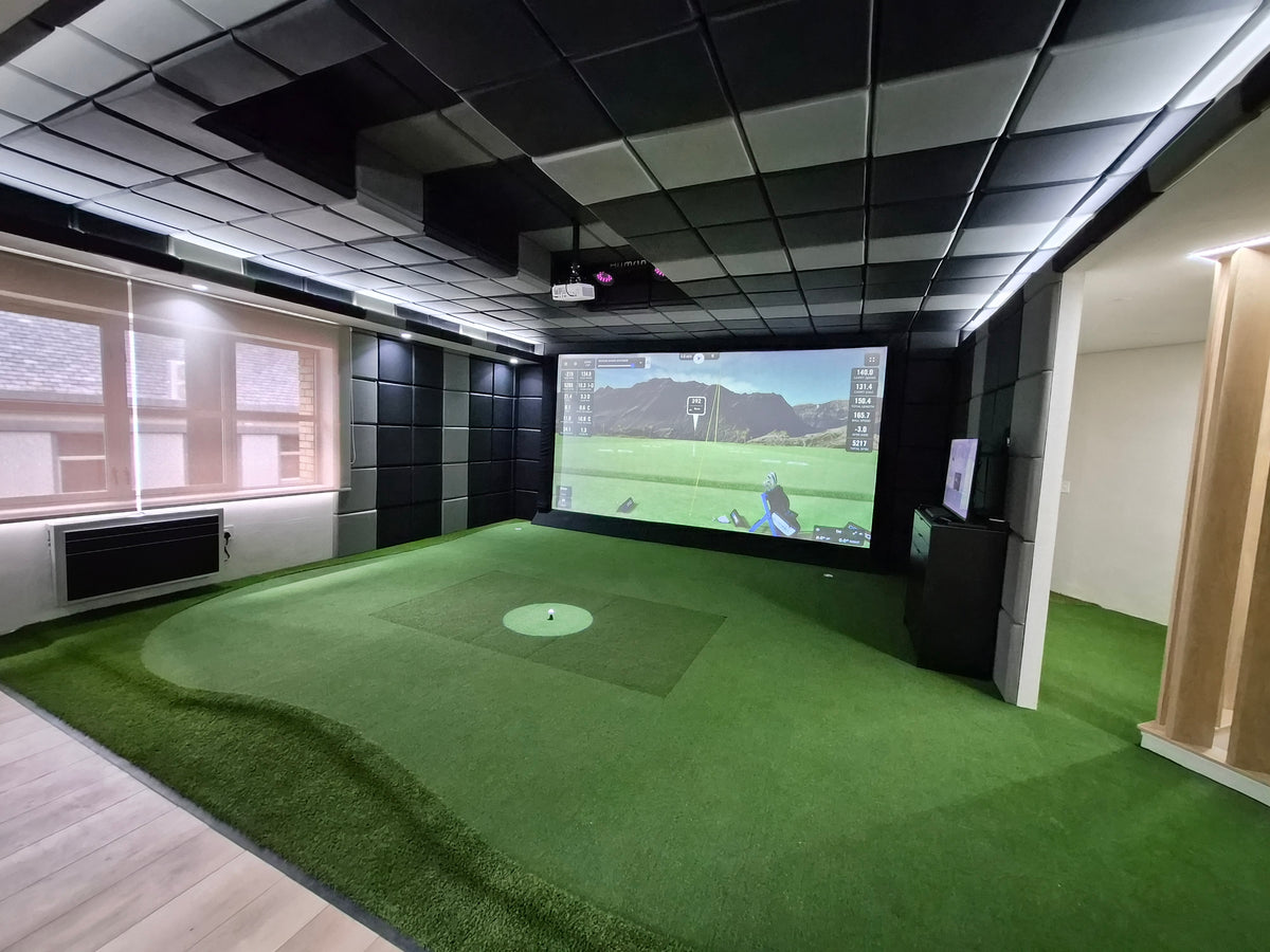 Custom commercial indoor golf simulator installation with large impact screen and overhead projector in a professional environment.