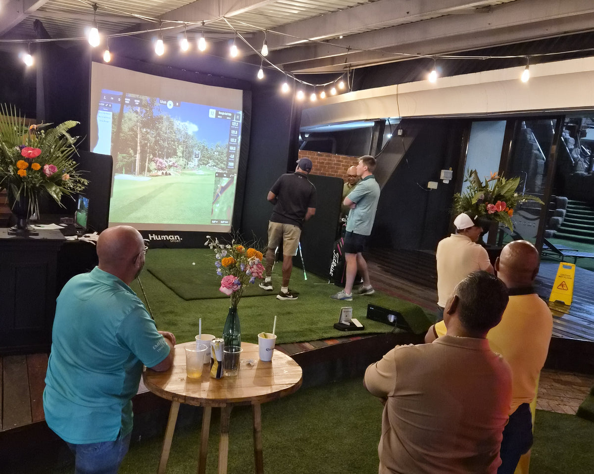Outdoor evening corporate event golf simulator rental with crowd