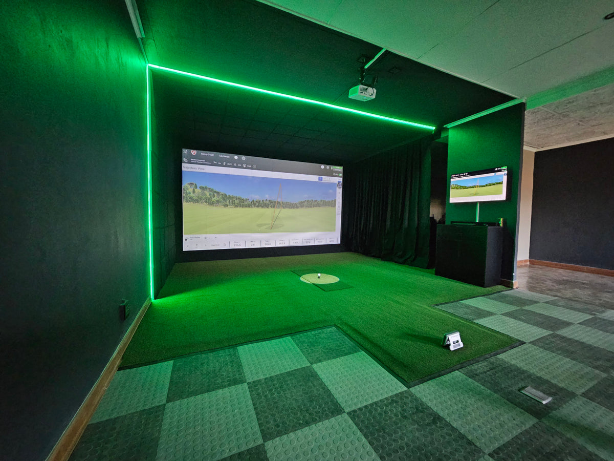 golf simulator setup with green neon lights surrounding the bay