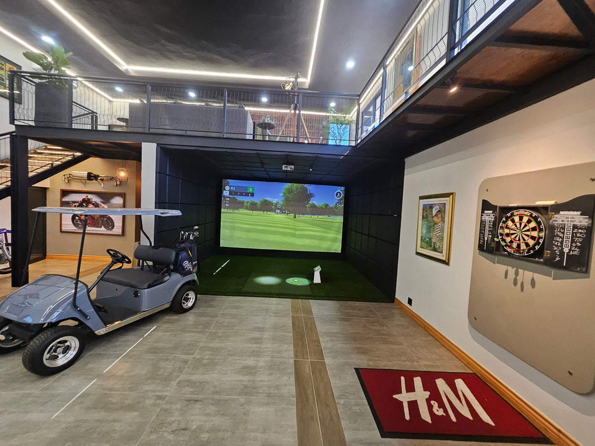 Commercial indoor golf simulator bay built beneath a steel mezzanine loft with golf cart parking and entertainment space in South Africa.