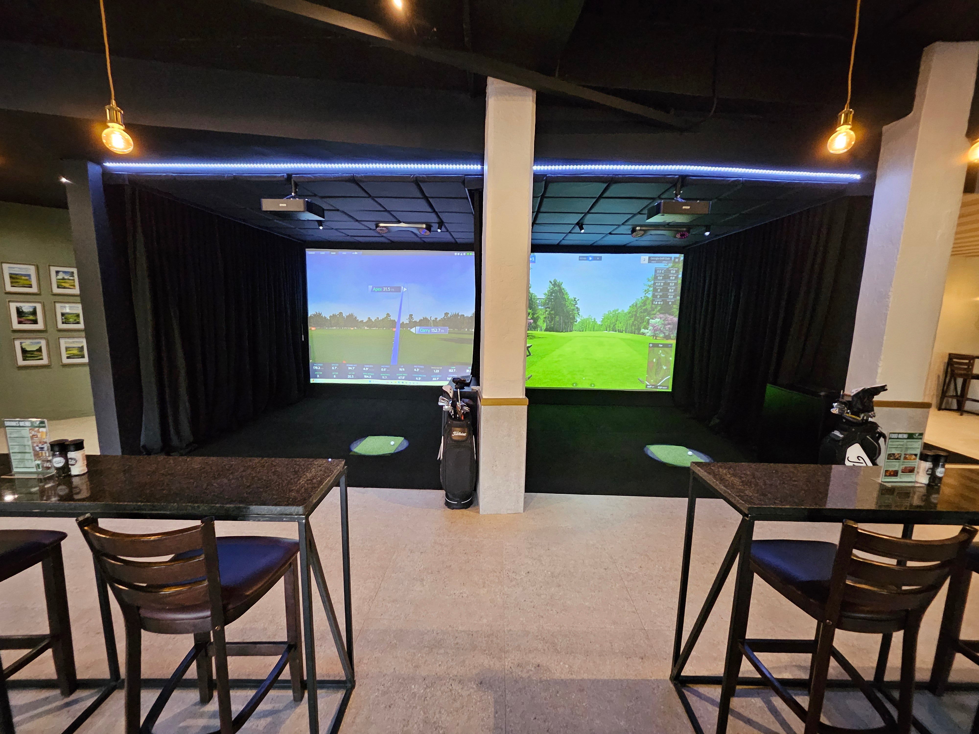 Dual bay commercial golf simulator setup with launch monitors and seating area for a premium indoor golf center in South Africa.
